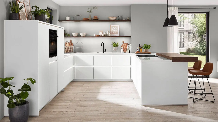 Eine strahlend weiße Küche mit braunen und schwarzen Akzenten.